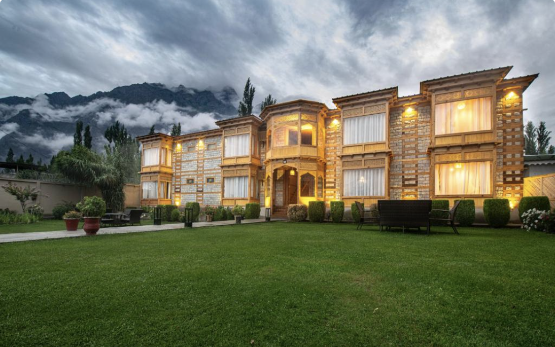 Khar Hotel exterior with mountain backdrop at dusk